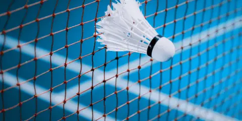 The shuttlecock getting stuck between the net while service